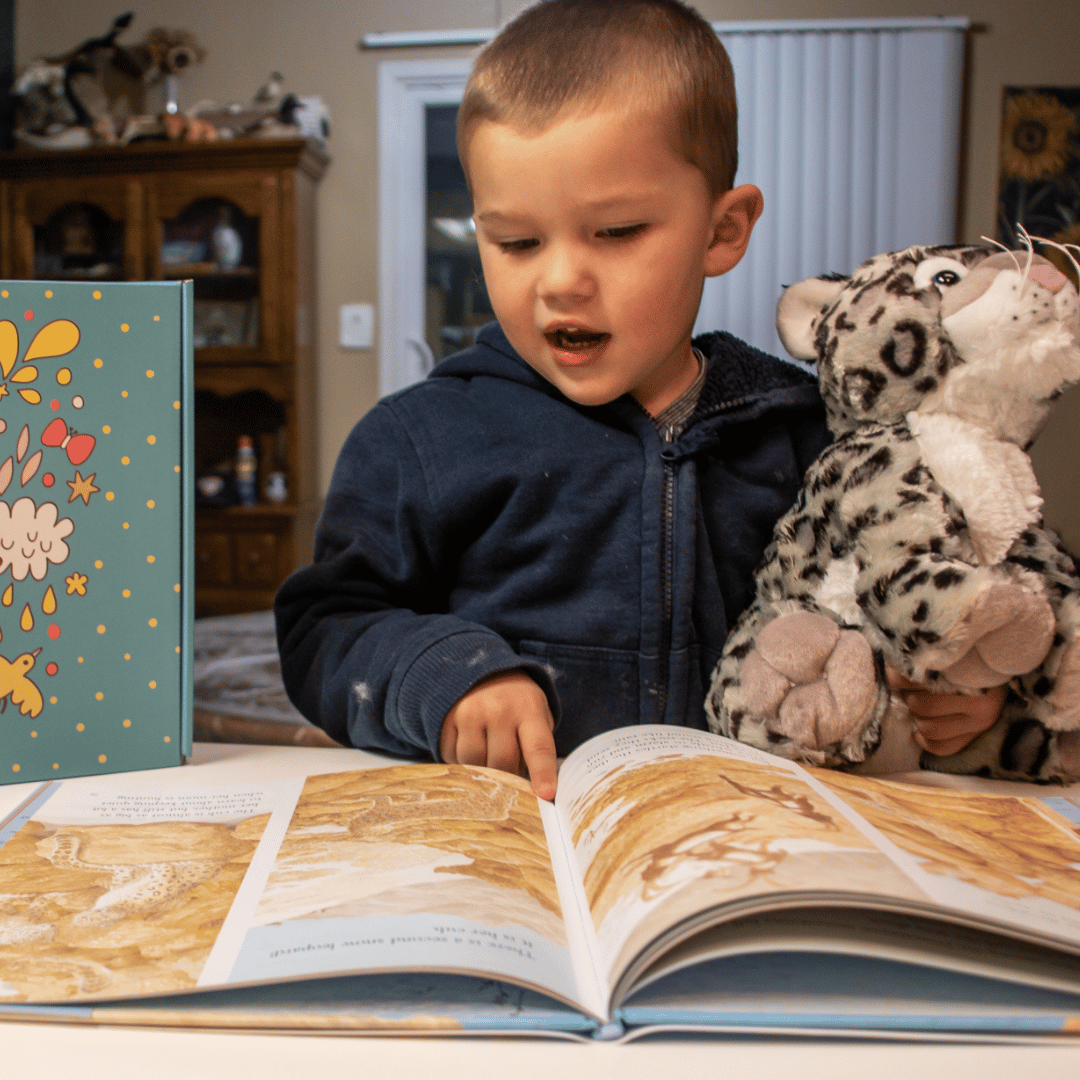 Boy reads his new book to the snow leopard he crafted