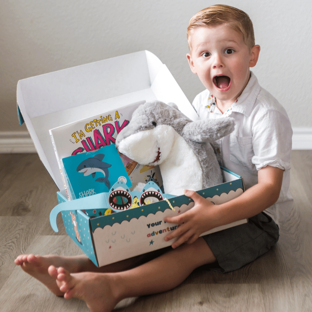 Boy holds open Shark Book and Bear Box