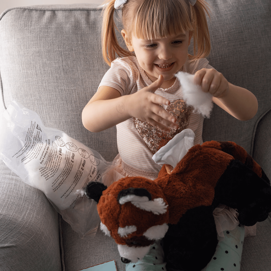 Little girl stuffing her new red panda friend